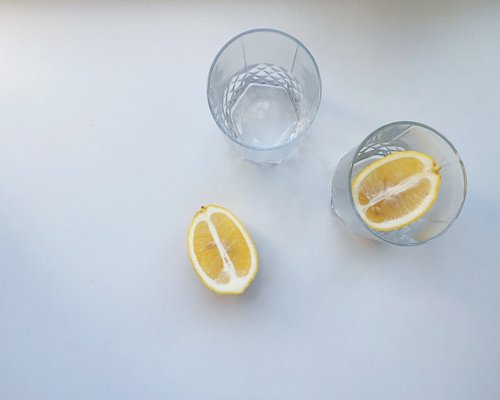 glass of fresh water with lemon on a table